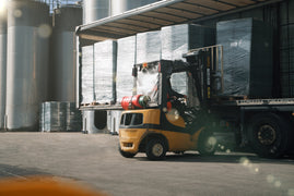 Forklift unloading pallets from a curtain-side lorry