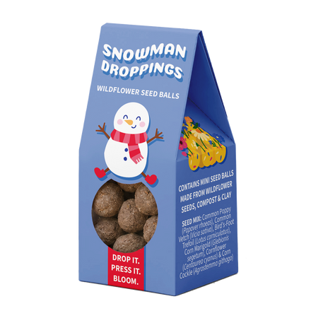 A blue stand-up packaging box for 'Snowman Droppings' wildflower seed balls, featuring a cartoon snowman, a clear window showing the brown seed balls inside, and a red label that reads 'DROP IT. PRESS IT.