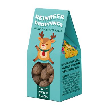 A teal stand-up pouch package labeled 'Reindeer Droppings' with a cartoon reindeer illustration, a clear window showing round seed balls, and product text on a white background.