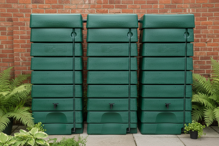 3 green wall tanks against a red brick wall