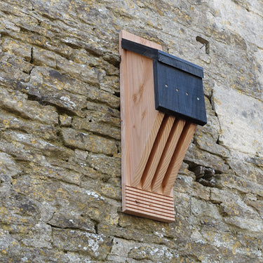 Wooden bat box attached to a stone wall
